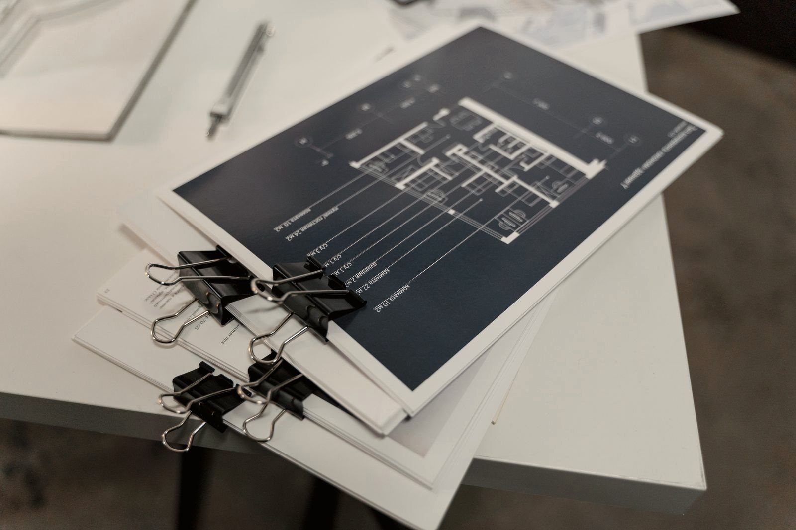 A bound stack of printed analytical reports held with clips on a white table