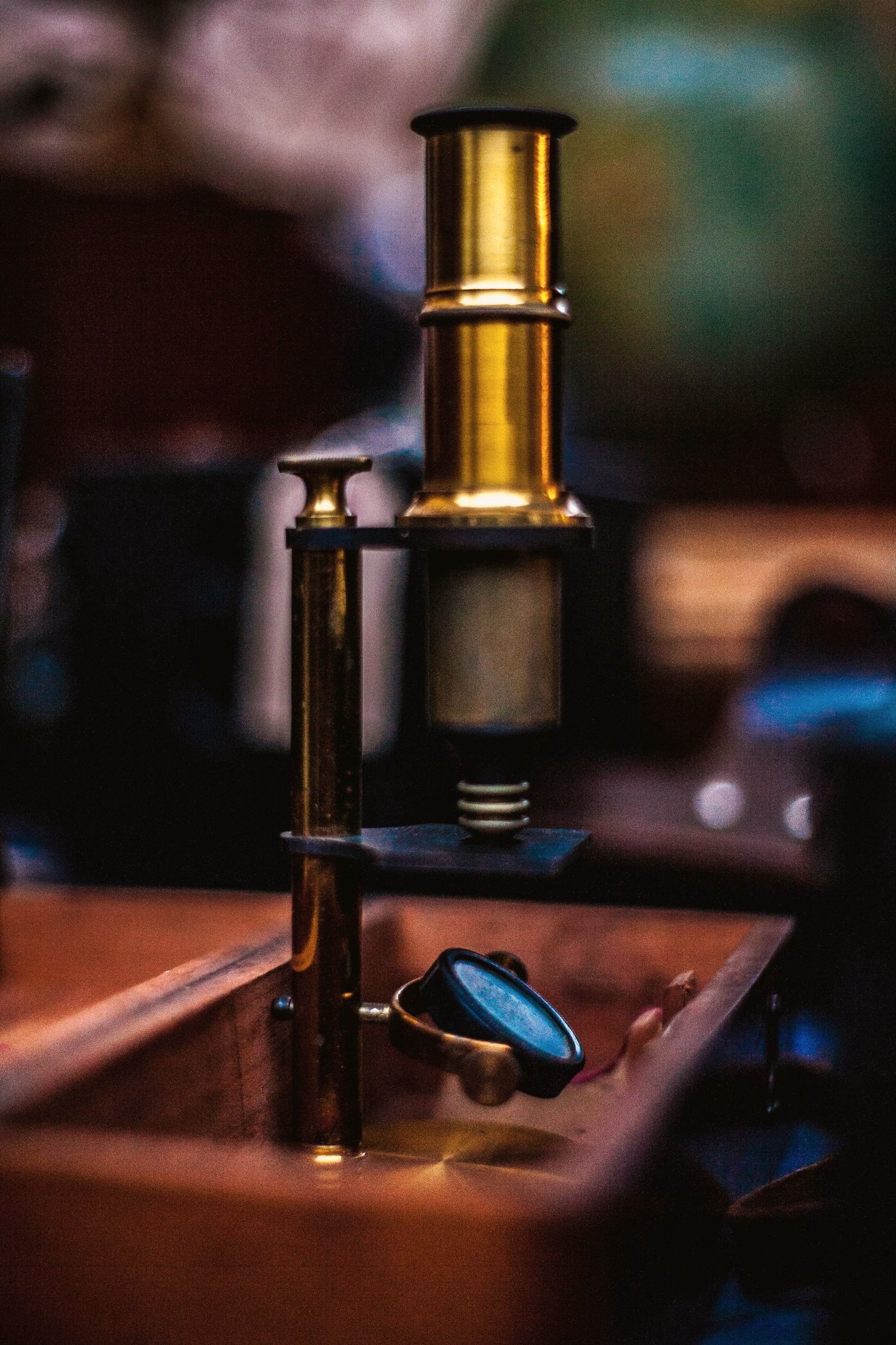 A research microscope standing on a laboratory table in neutral light